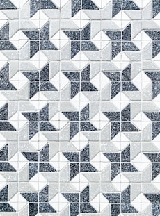 a black and white tiled wall with a pattern of stars
