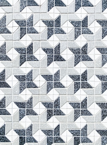 a black and white tiled wall with a pattern of stars