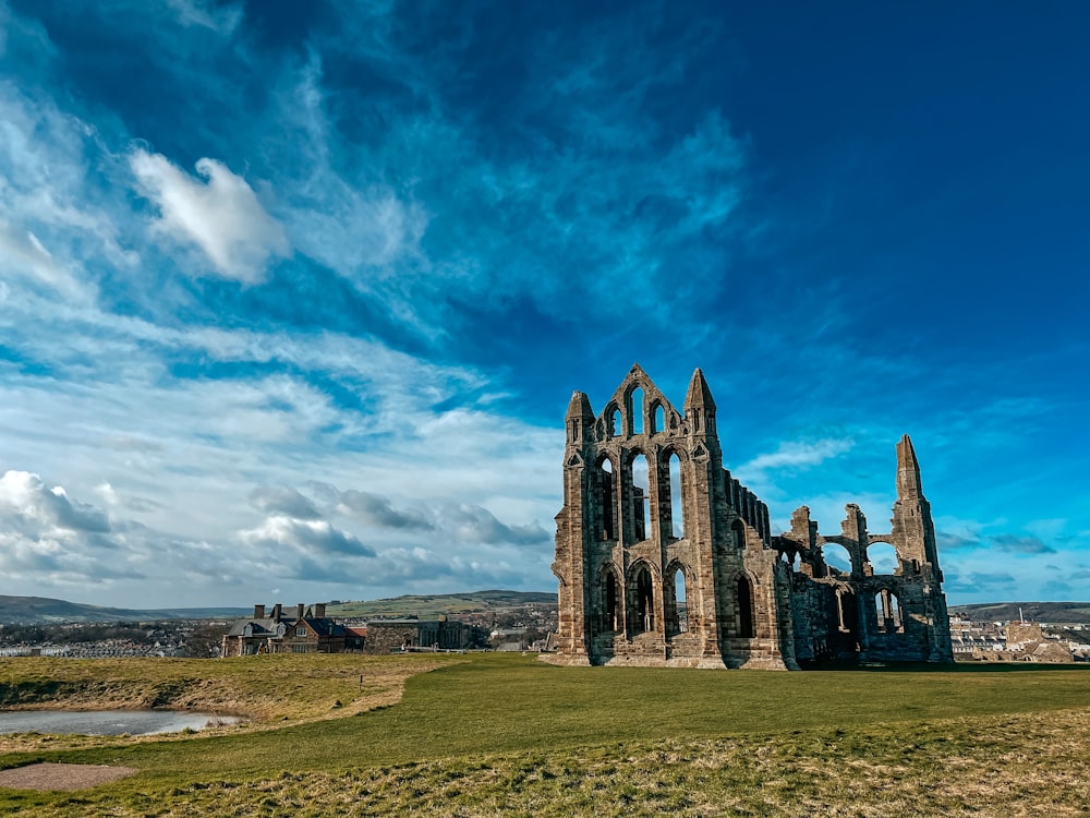 a large stone building sitting on top of a lush green field