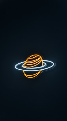 A neon light depiction of a planet with rings, resembling Saturn. The planet is illustrated with glowing orange and yellow lines, while the rings are represented by bright white neon outlines against a dark background.