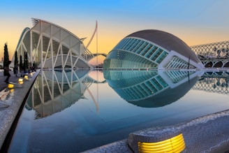 A stunning 3D render showing a modern villa at sunset with glowing blue accents highlighting architectural details.