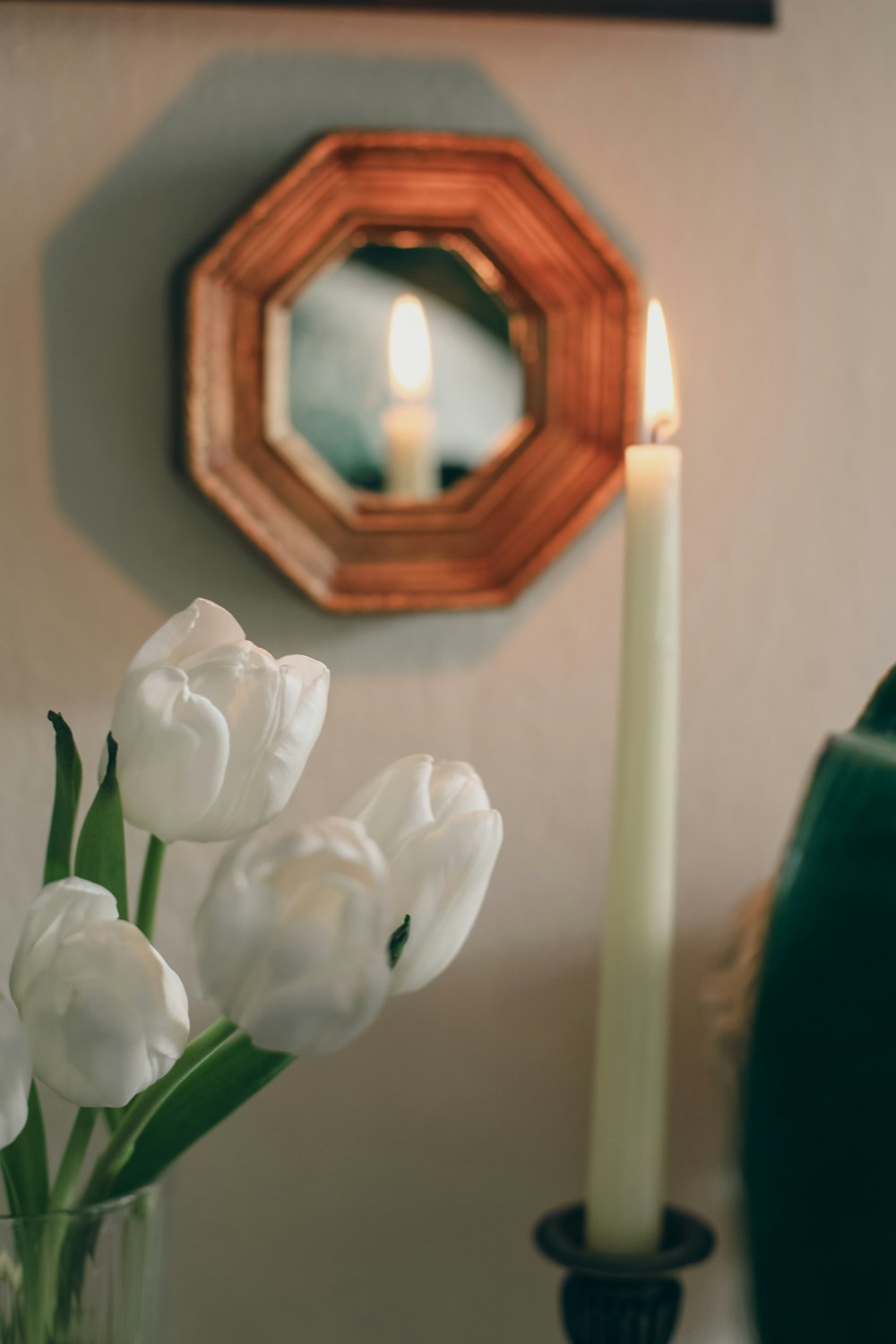 a vase filled with white flowers next to a mirror