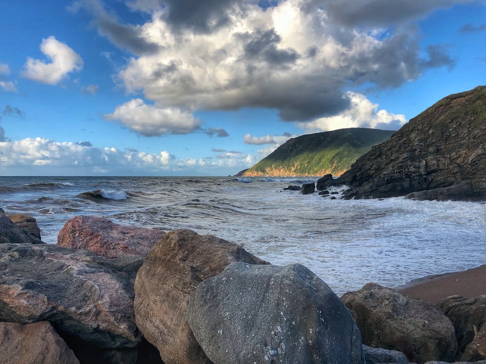 a rocky beach with large rocks and a body of water