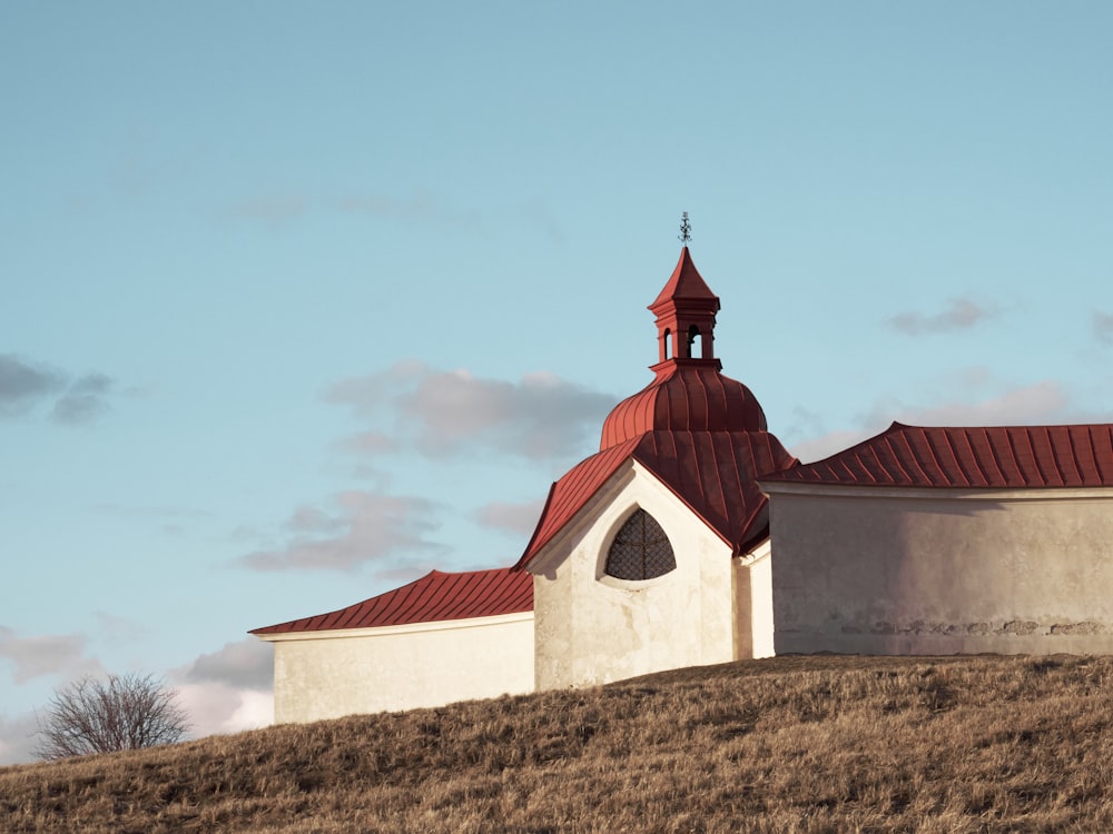 a church on a hill with a red roof