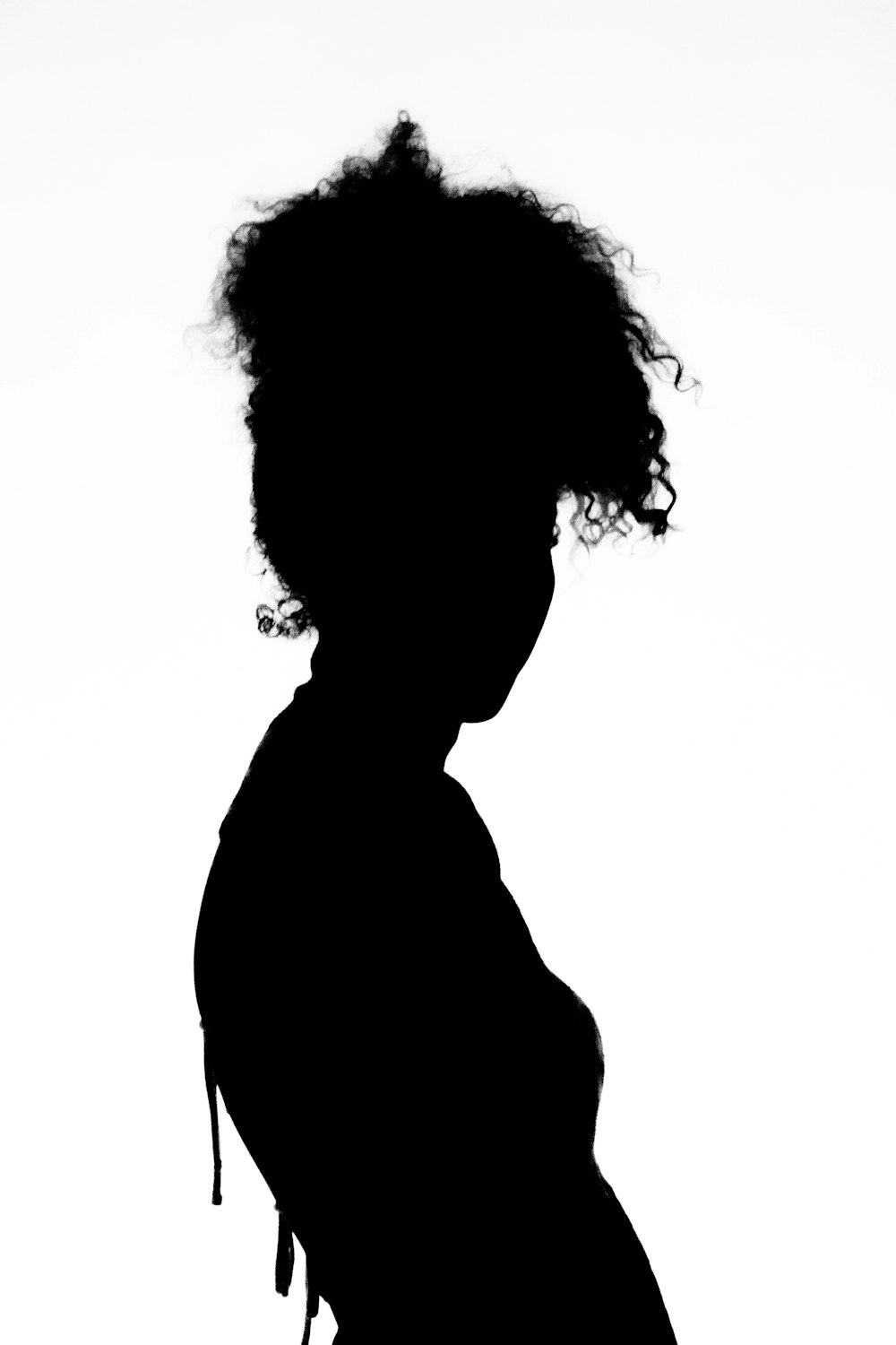 a silhouette of a woman with curly hair
