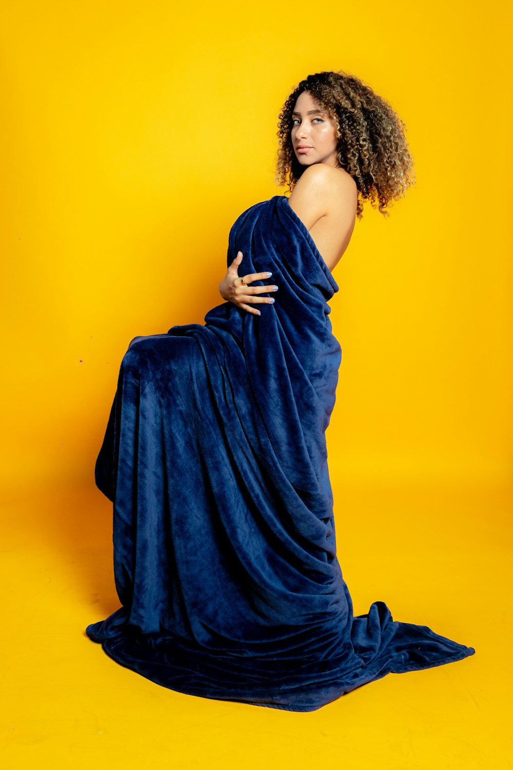a woman is wrapped in a blue blanket