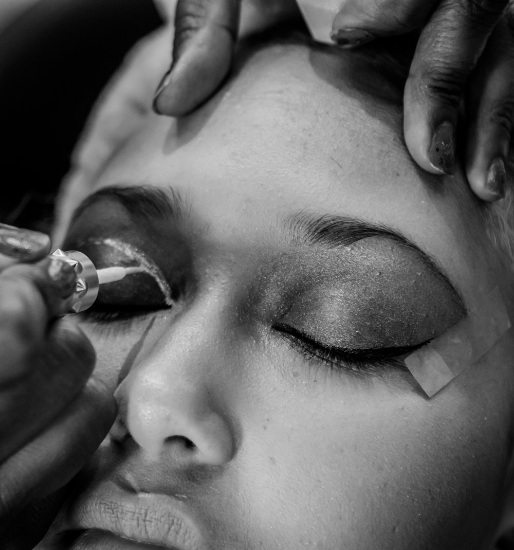 a woman getting her make - up done by a professional make - up artist