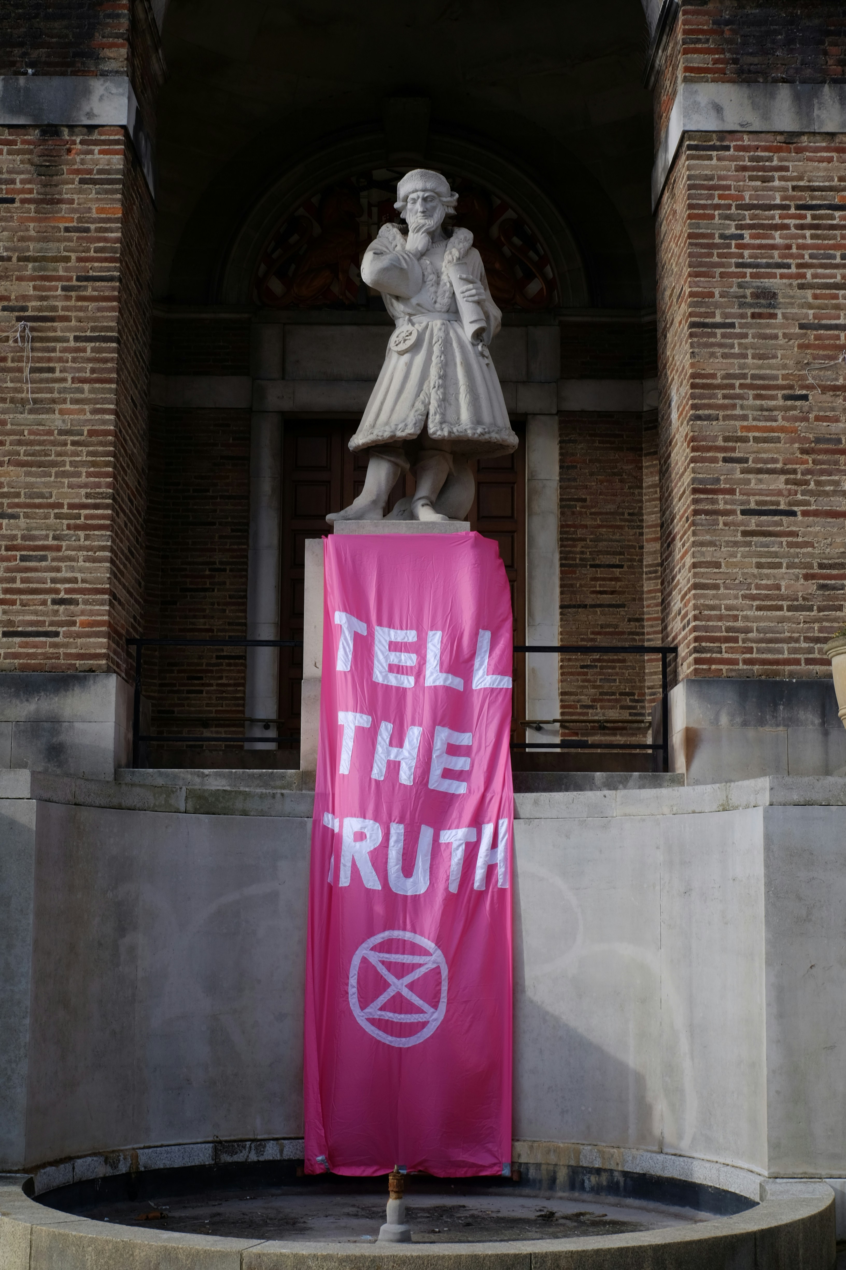 una pancarta rosa con una estatua de una mujer encima