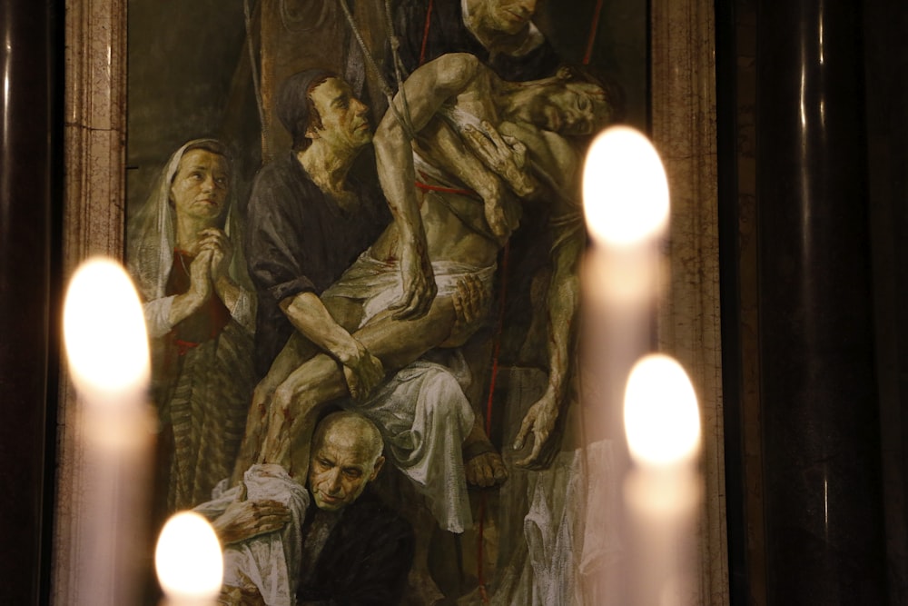 a painting of a group of people with candles in front of it