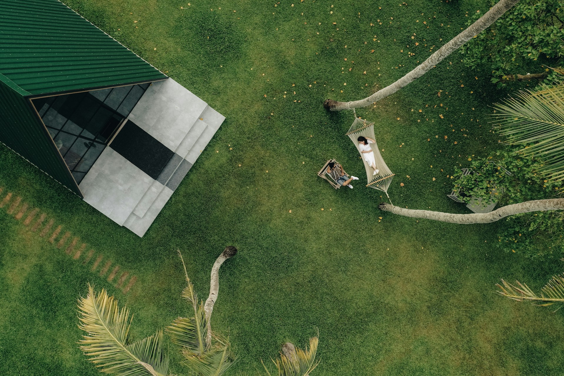 a couple of people sitting on top of a lush green field