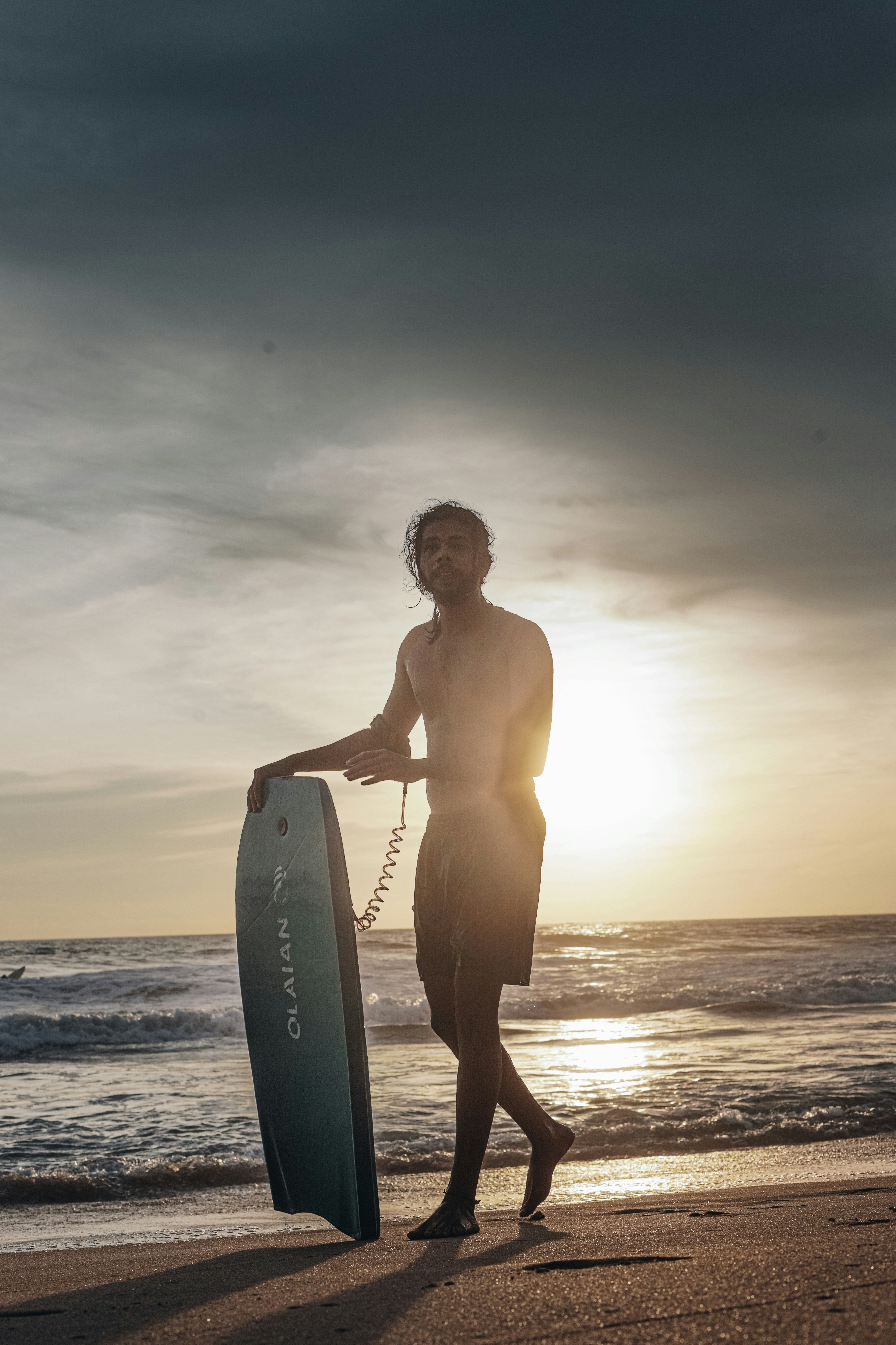 a man holding a surfboard while walking on a beach