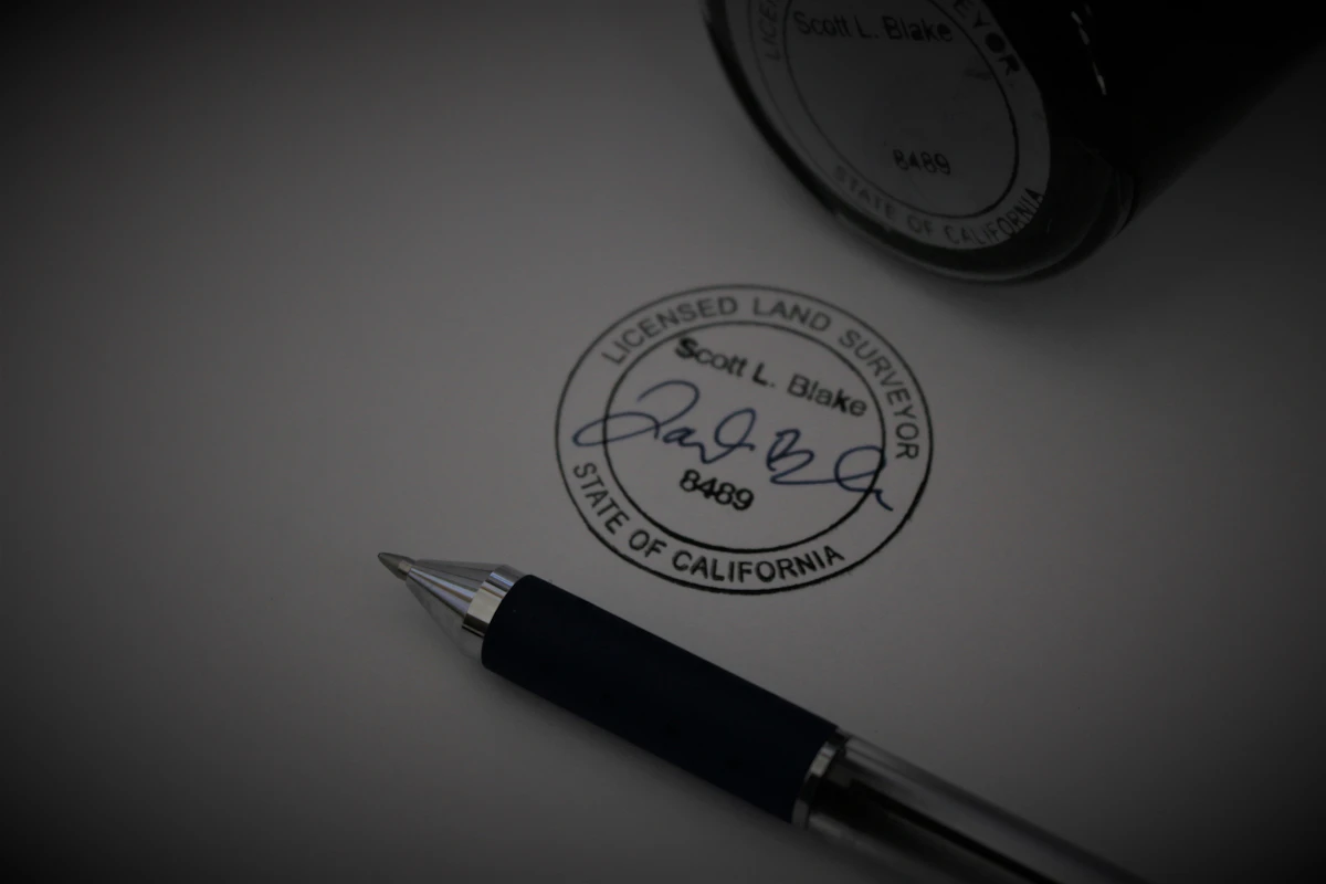 Pen beside an official seal and signature