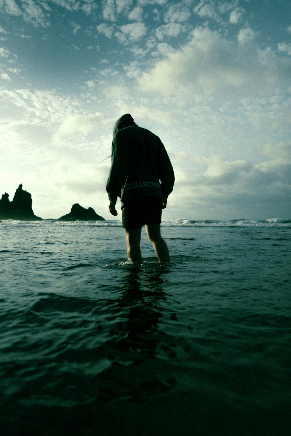 a person standing in the water looking at the ocean