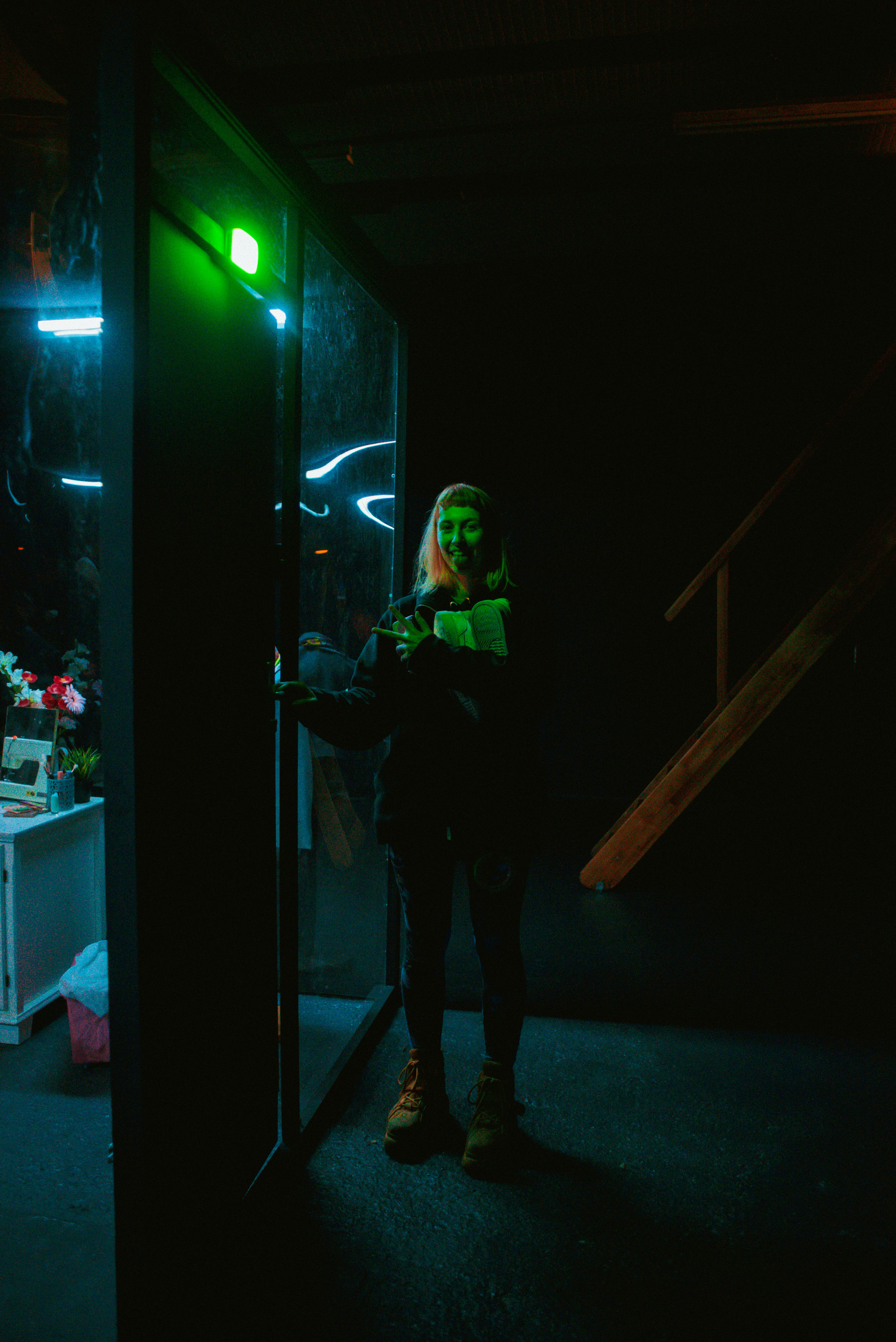a person standing in a dark room with a green light