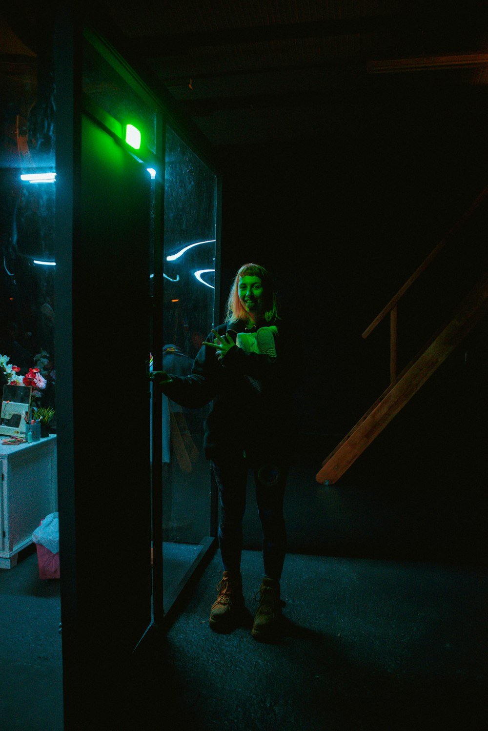 a person standing in a dark room with a green light