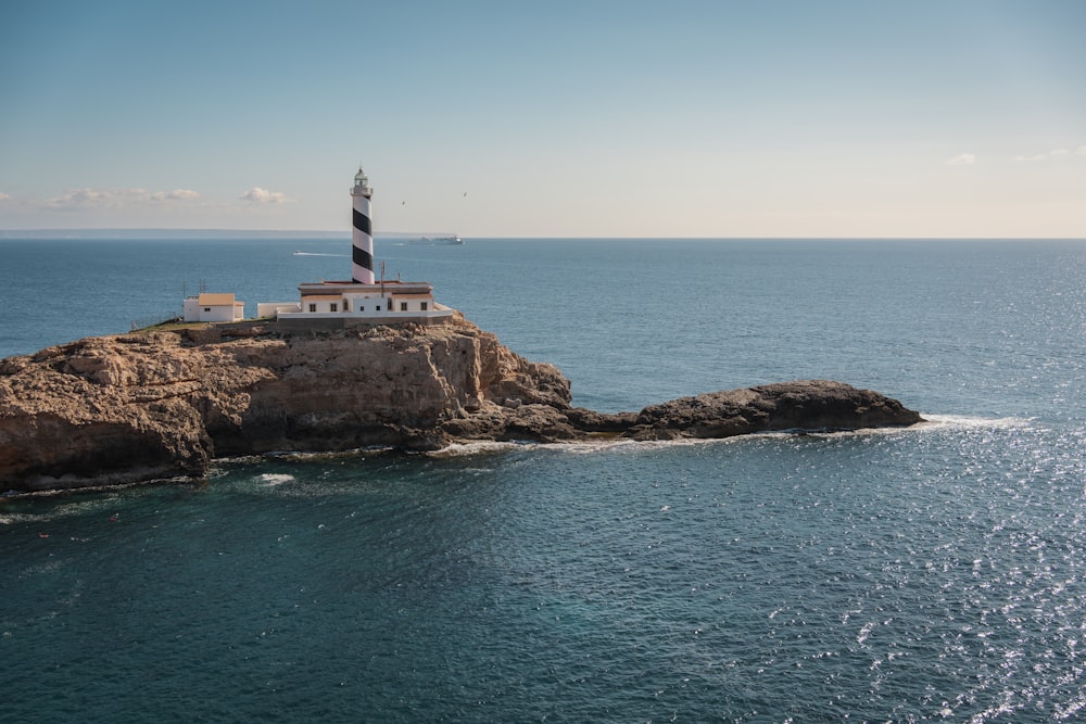 a lighthouse on an island in the middle of the ocean