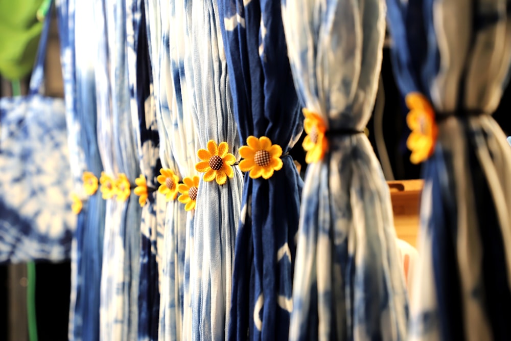 a row of blue and white dresses with yellow flowers on them