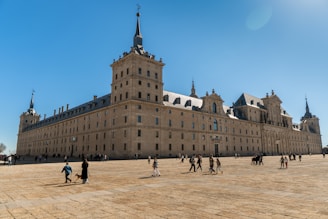 a group of people walking around in front of a large building