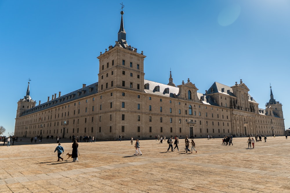 un groupe de personnes se promenant devant un grand bâtiment