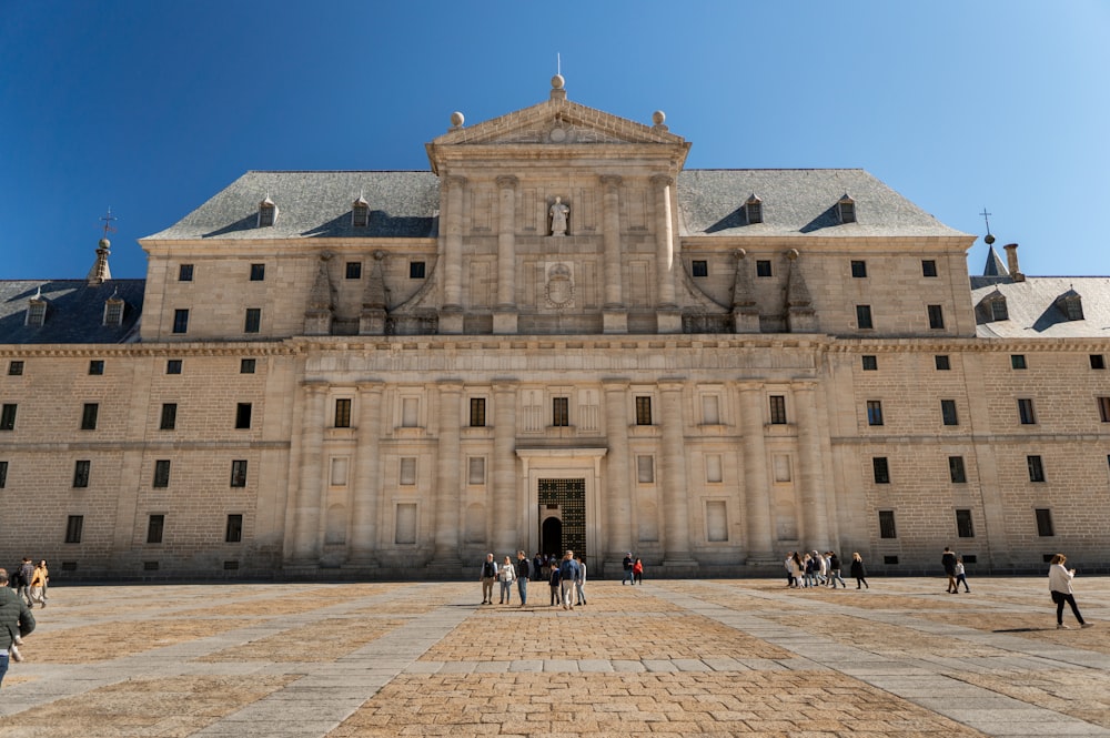 a group of people standing in front of a large building