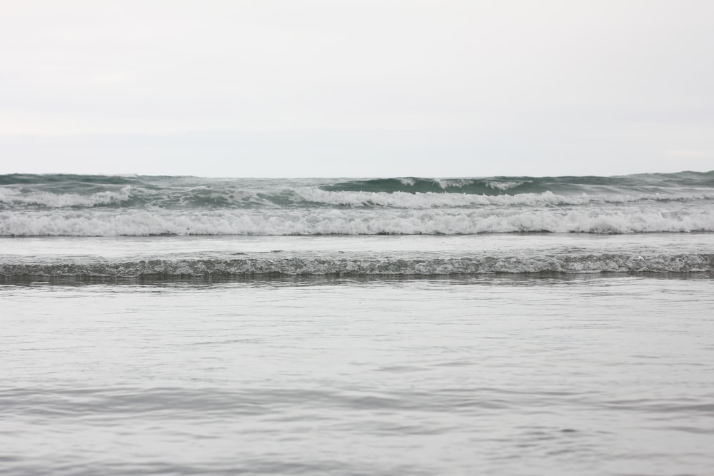 a person standing in the ocean with a surfboard