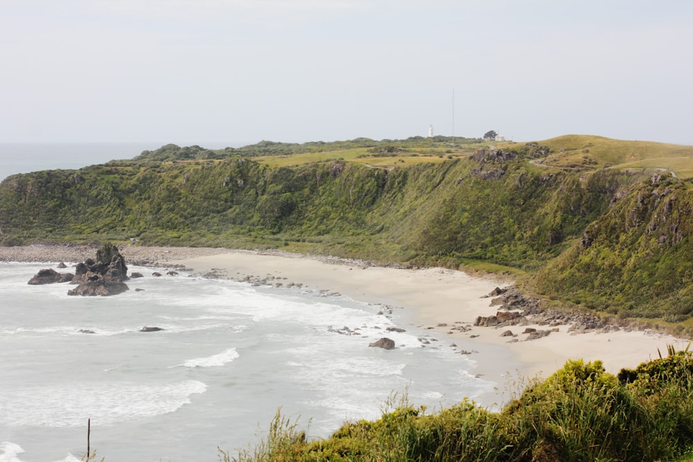 a view of a beach from a hill overlooking the ocean