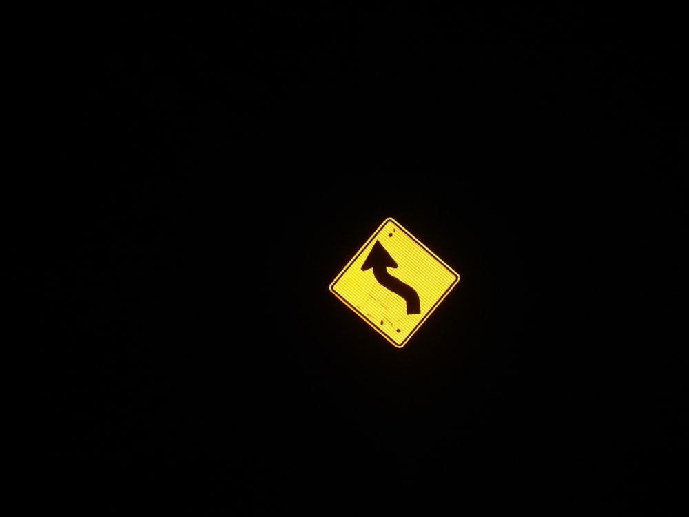 a yellow street sign sitting on the side of a road