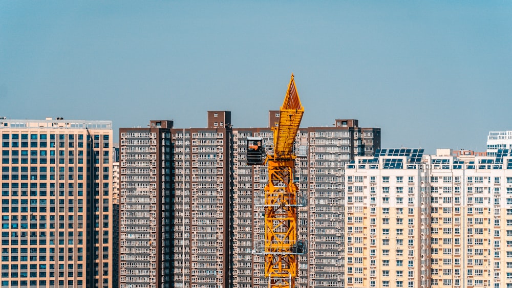 a crane is standing in front of some tall buildings