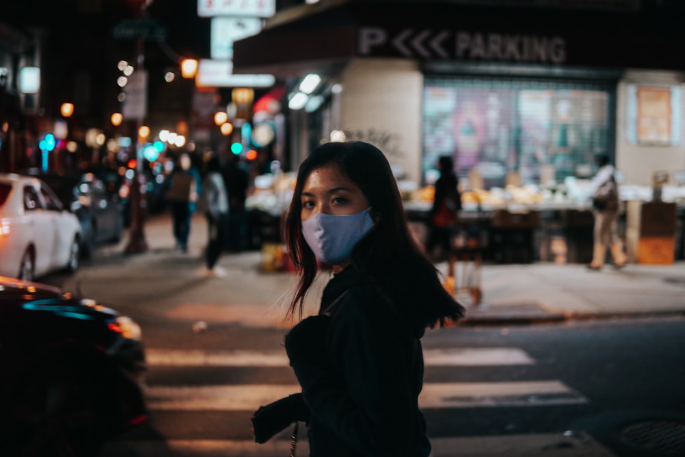 a woman wearing a face mask on a city street