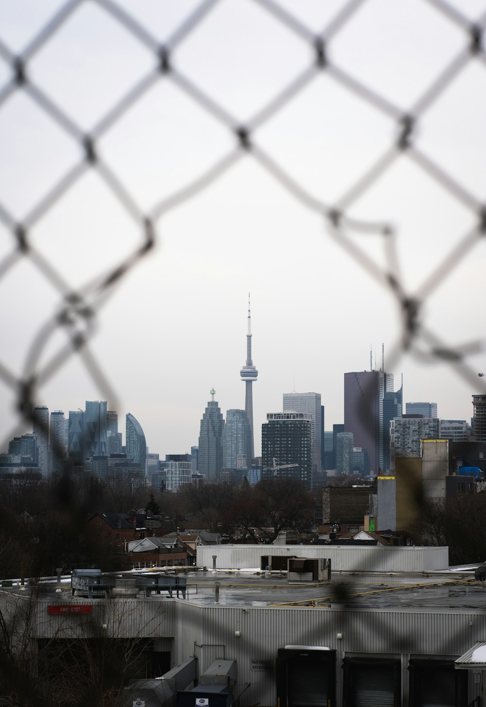 a view of a city through a chain link fence