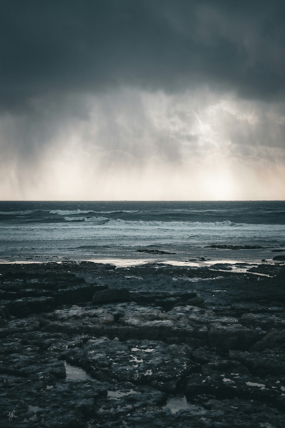 a large body of water under a cloudy sky