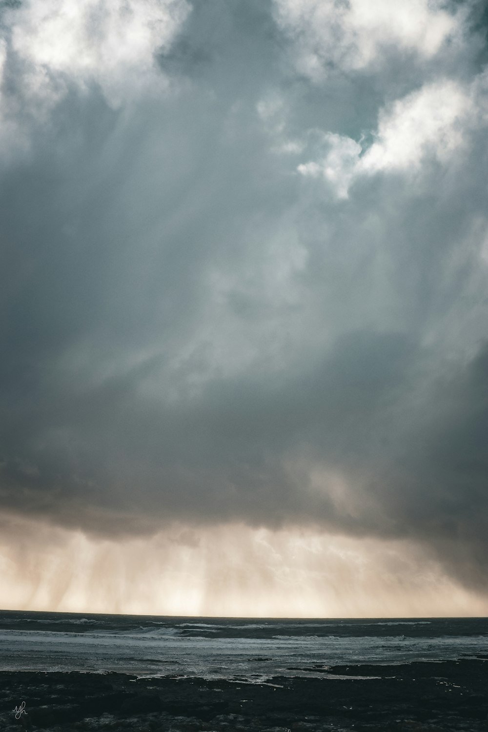 a large body of water under a cloudy sky