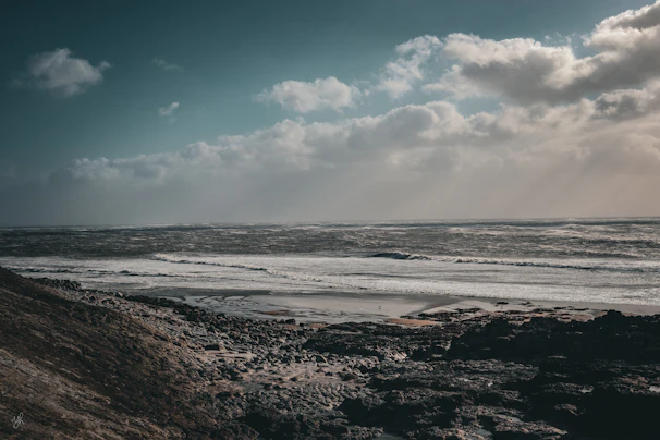 A dramatic stormy sky over the wild Atlantic, dark clouds rolling above restless sea and jagged shore.