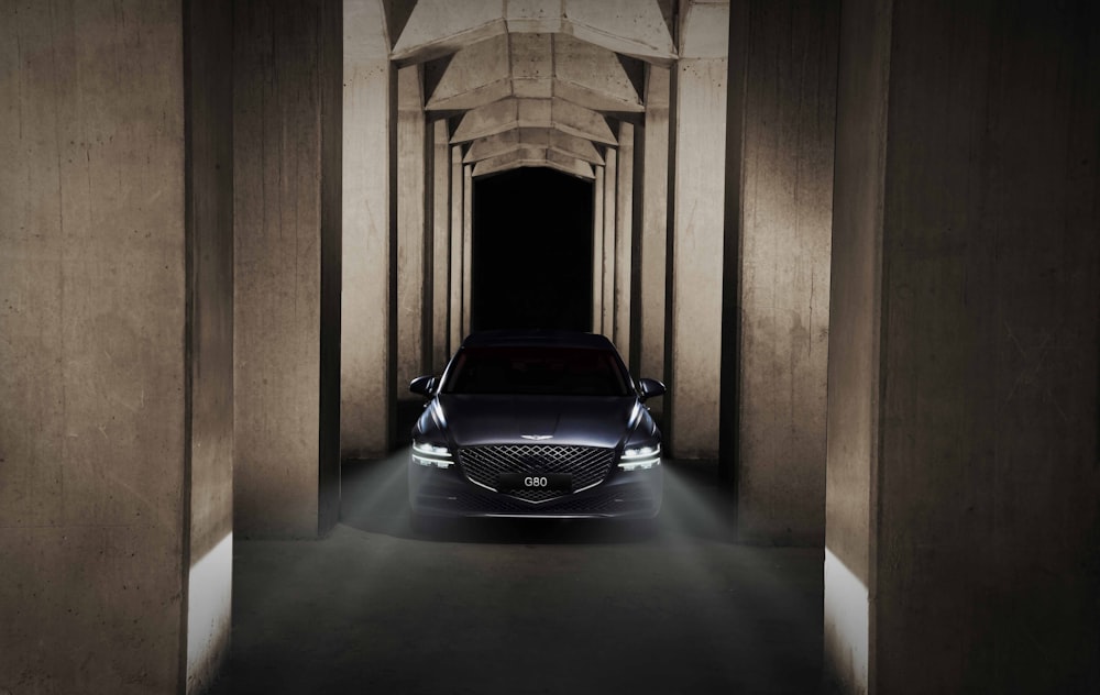 a car is parked in a tunnel of concrete