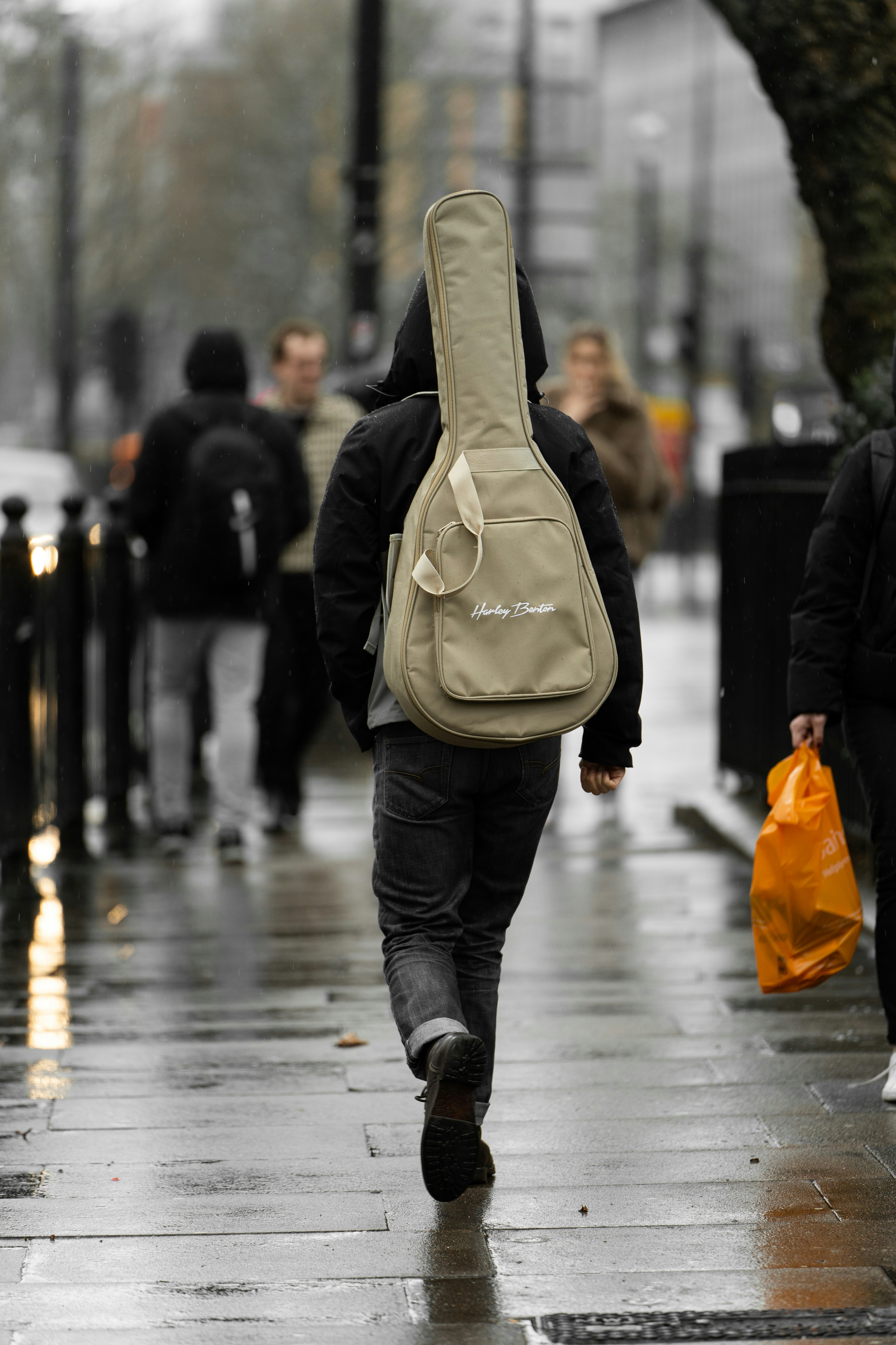 a man with a guitar case walking down the street