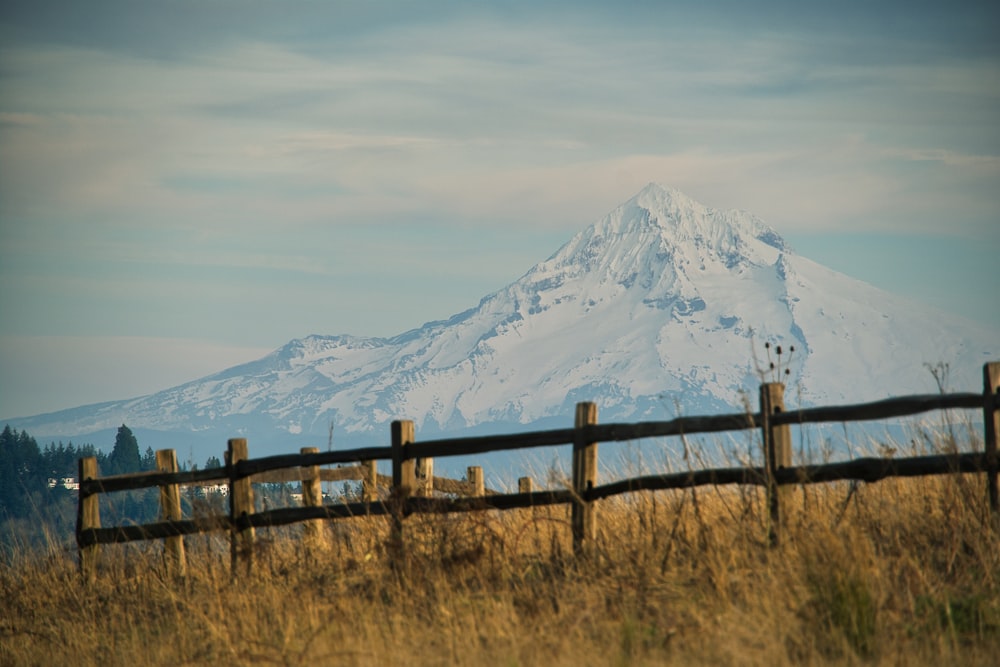a wooden fence with a mountain in the background