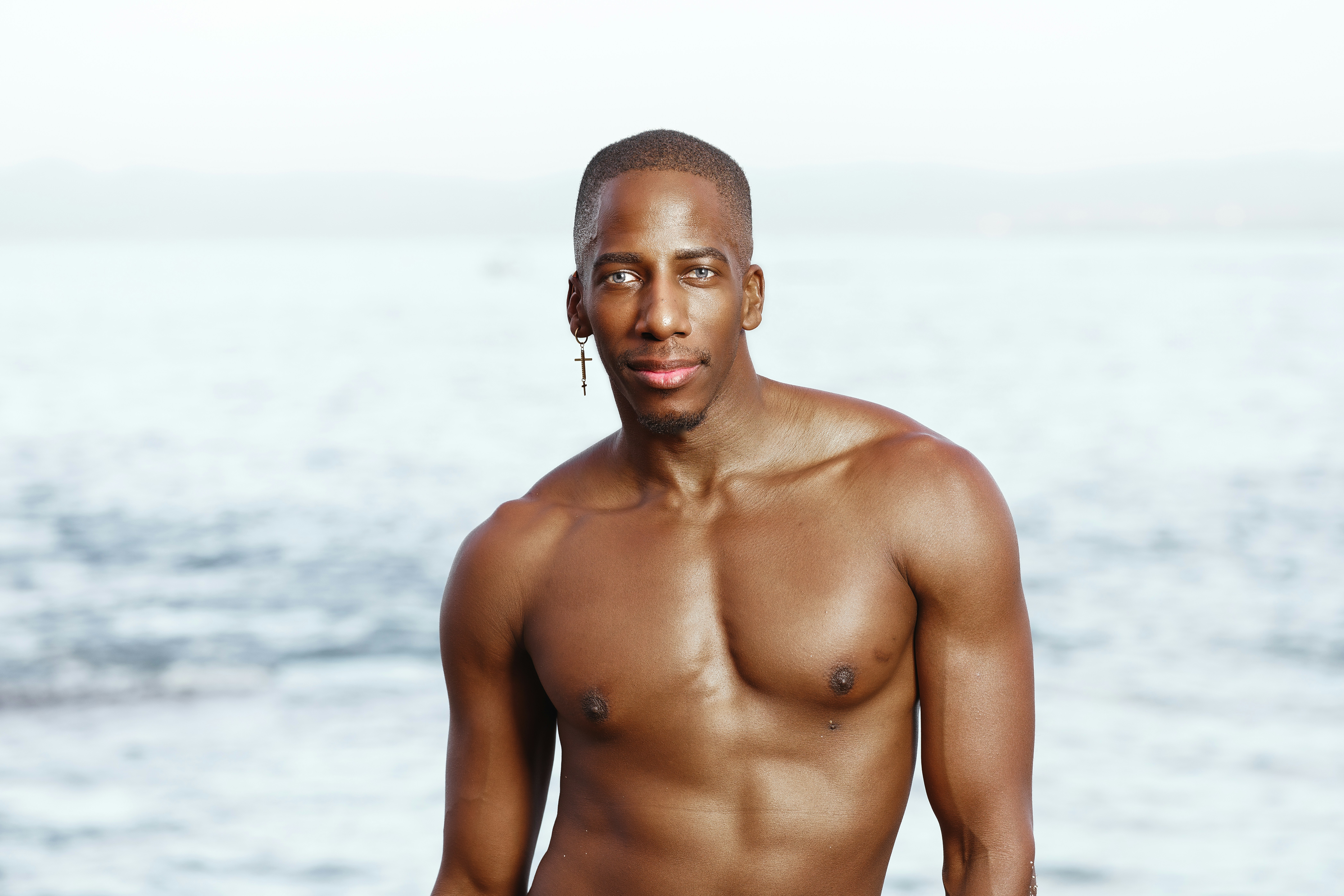 Un hombre sin camisa parado frente al océano