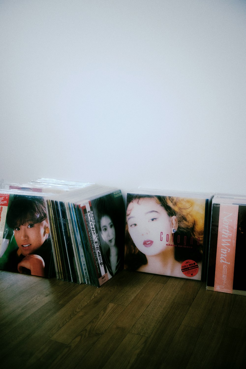 a stack of cds sitting on top of a wooden floor