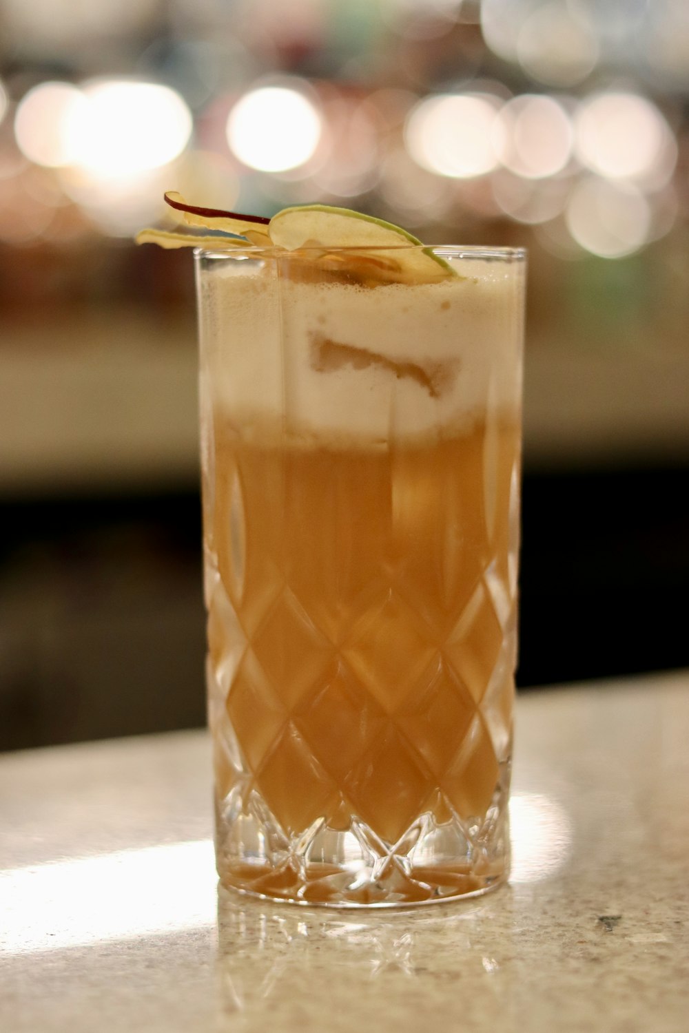 a glass with a drink on a table