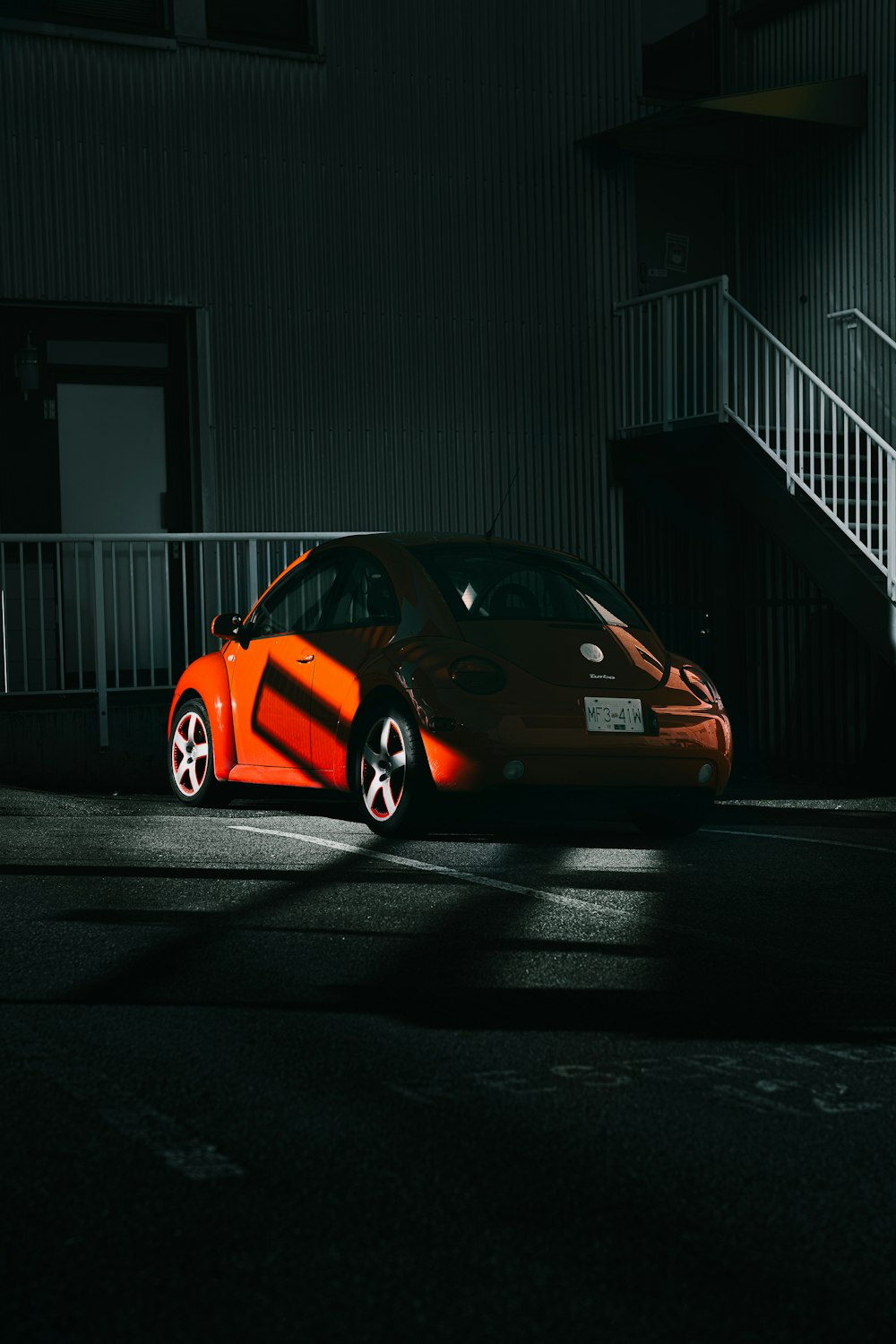 an orange sports car parked in front of a building
