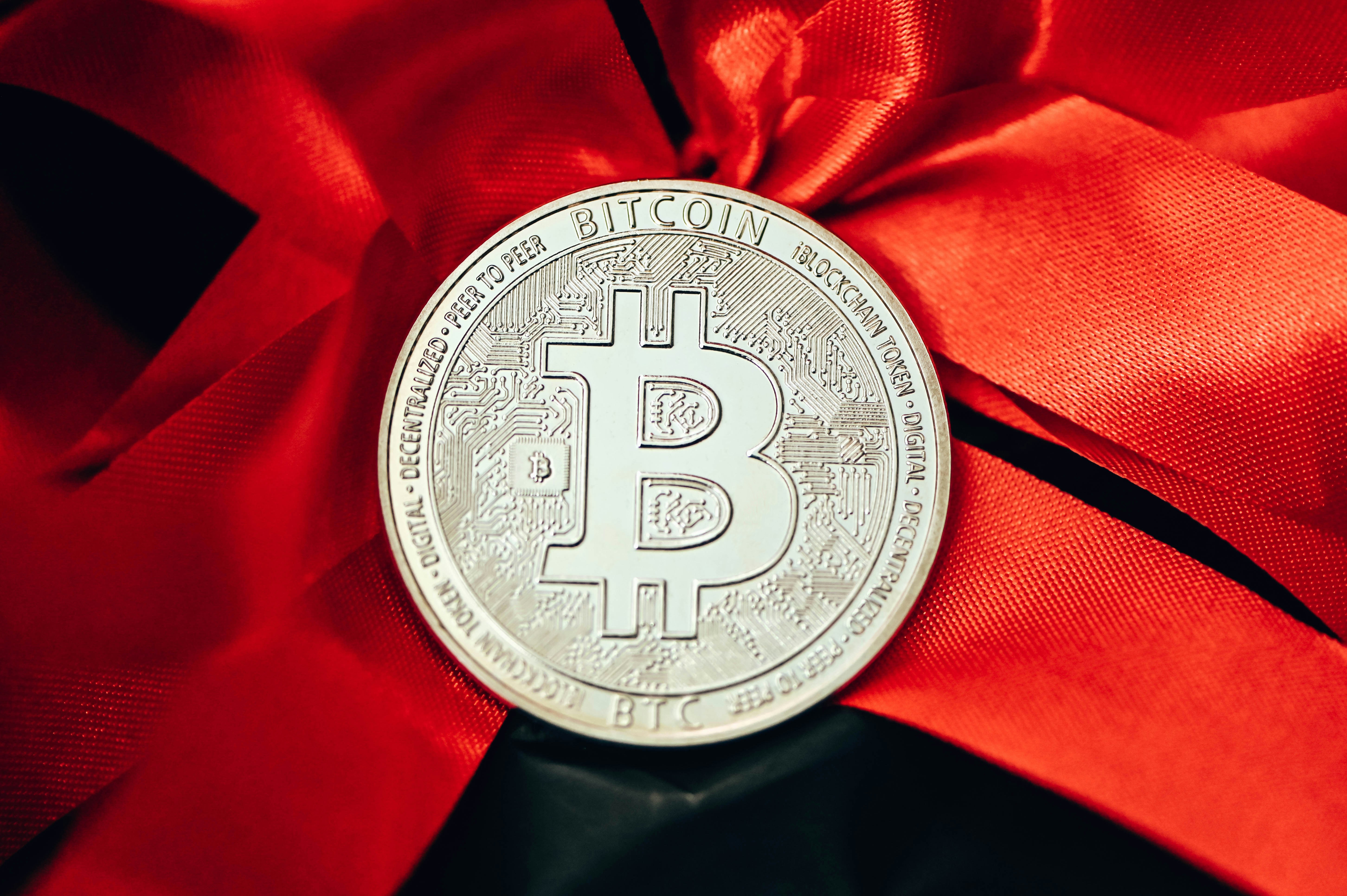 A bitcoin sitting on top of a red ribbon photo – Free Money Image on ...