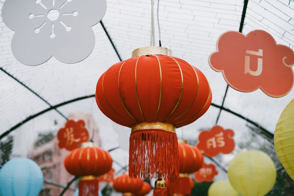 a bunch of red and yellow lanterns hanging from a ceiling