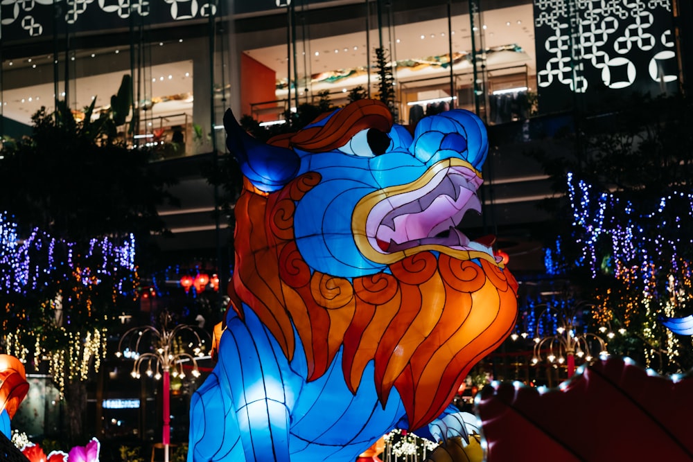 a blue and orange lion statue in front of a building