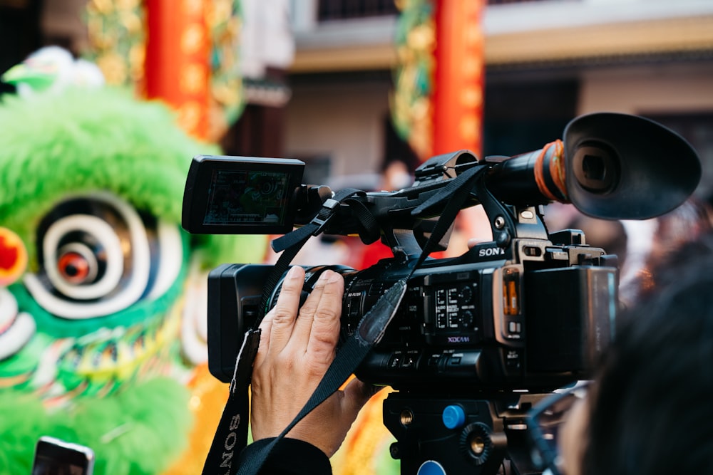 a person holding a camera in front of a dragon