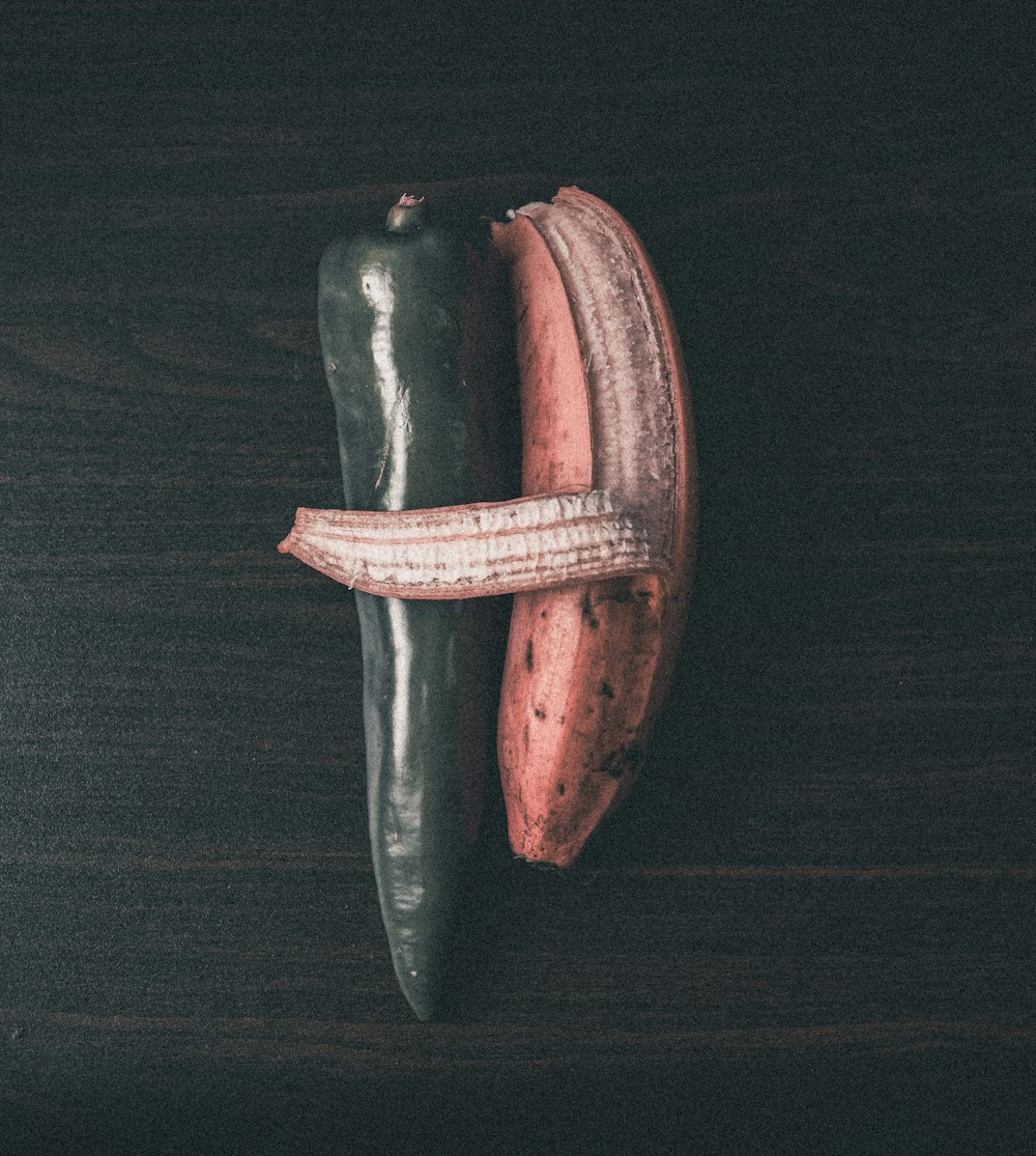 a couple of green and red peppers sitting on top of a wooden table