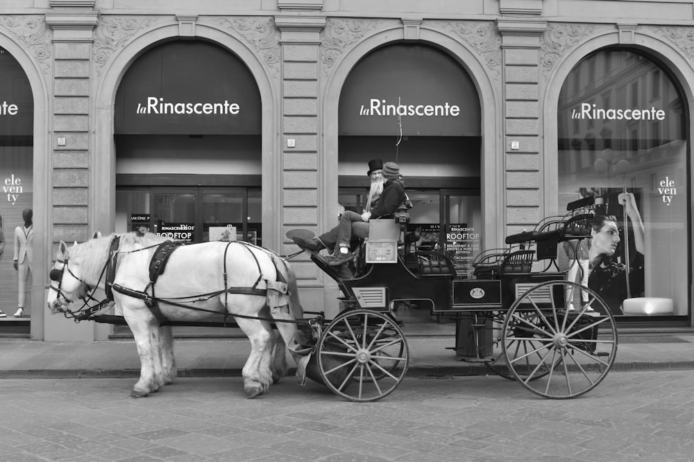 Una foto in bianco e nero di un cavallo che traina una carrozza