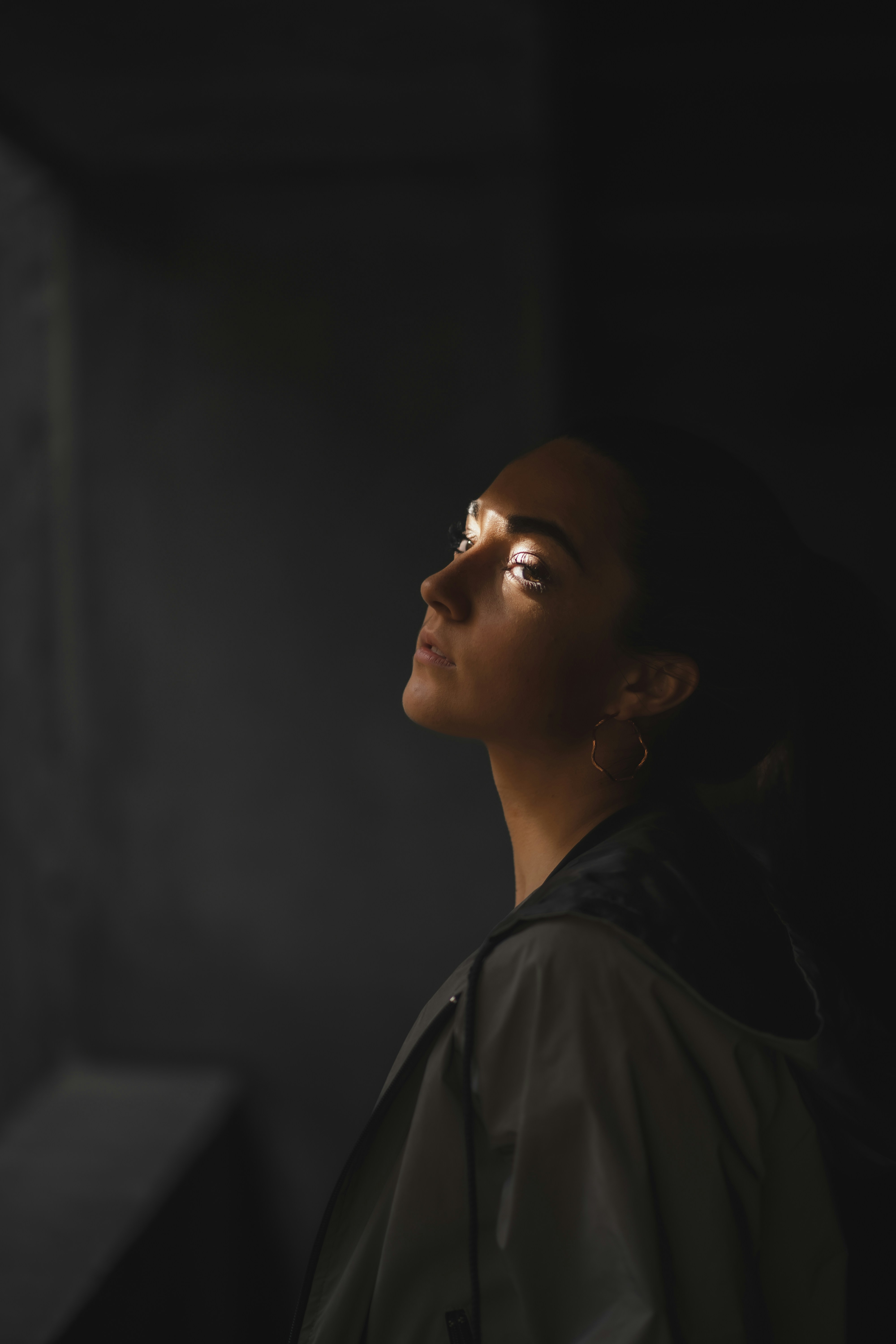 a woman in a black jacket looking off into the distance