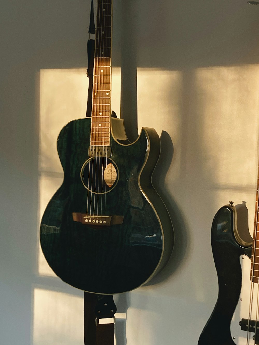 two guitars are hanging on a wall