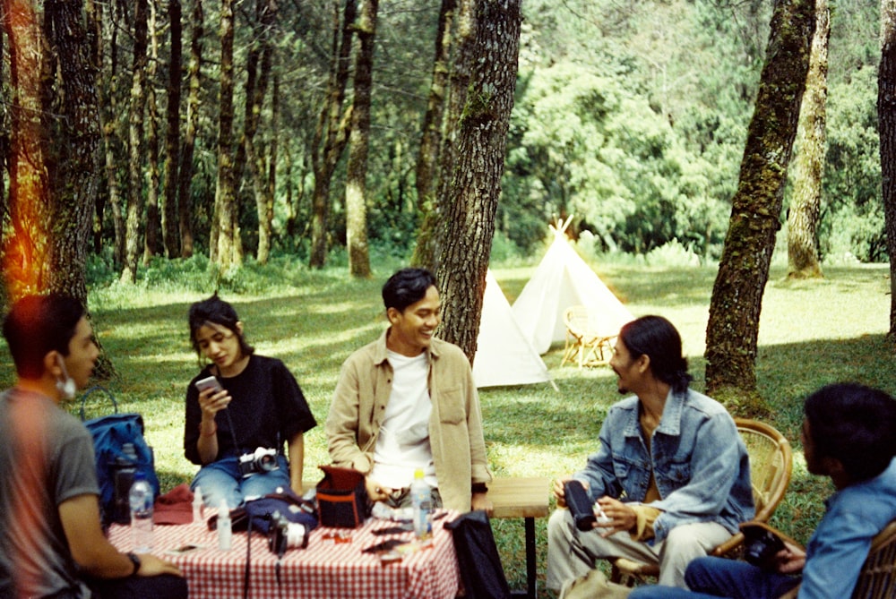 a group of people sitting around a picnic table