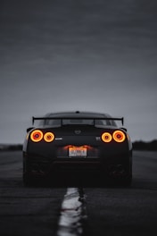 a black sports car with its lights on